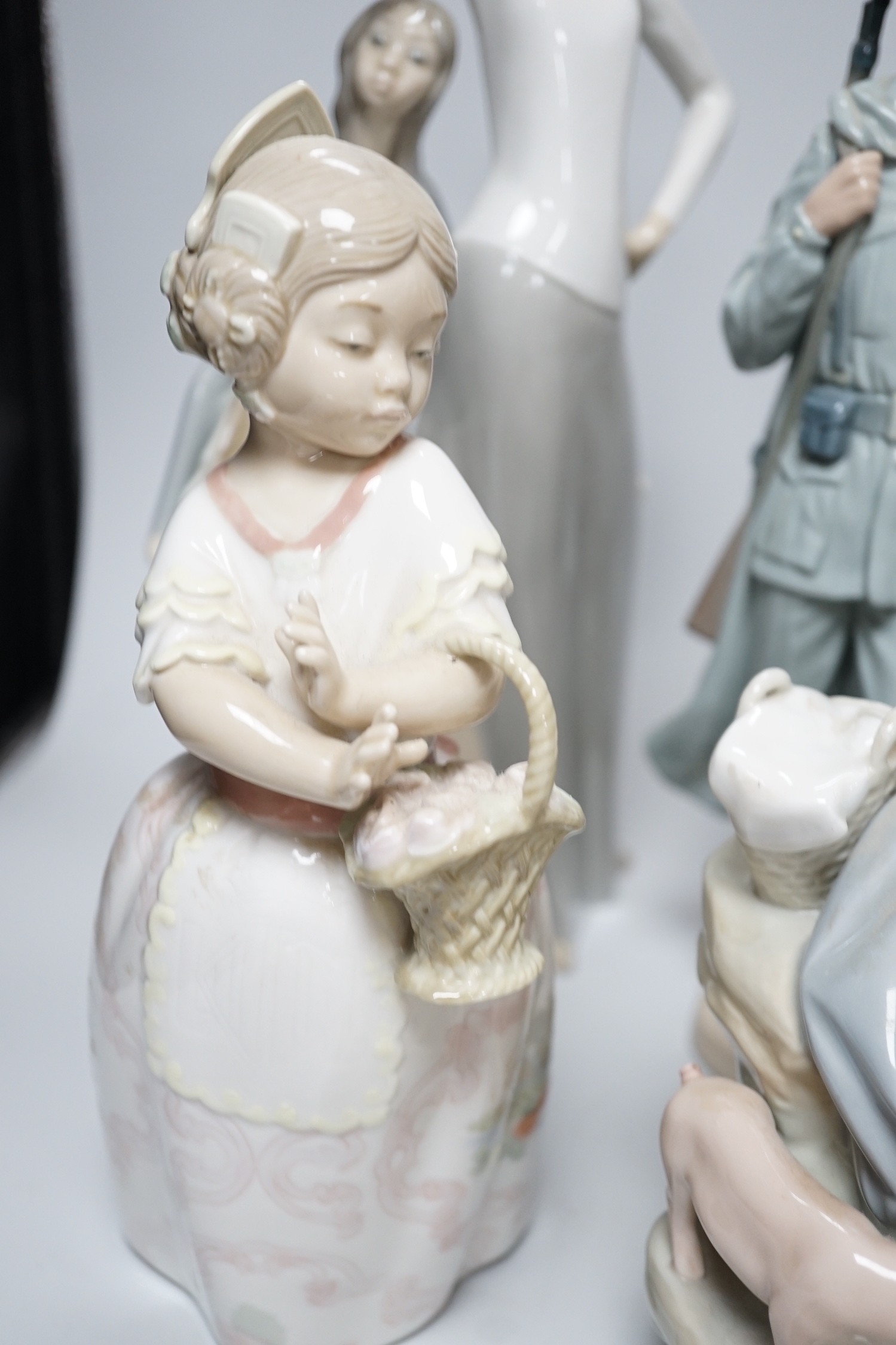 A collection of nine Lladro porcelain figures, tallest 36cm